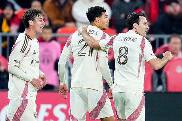 D.C. United forward Nathan Ordaz (22), left, and midfielder Jared Stroud (8) celebrate a goal from D.C. United midfielder Andre Dozzell (21) during the first half of an MLS soccer game in Toronto, Wednesday, Oct. 28, 2026. (Frank Gunn/The Canadian Press via AP)