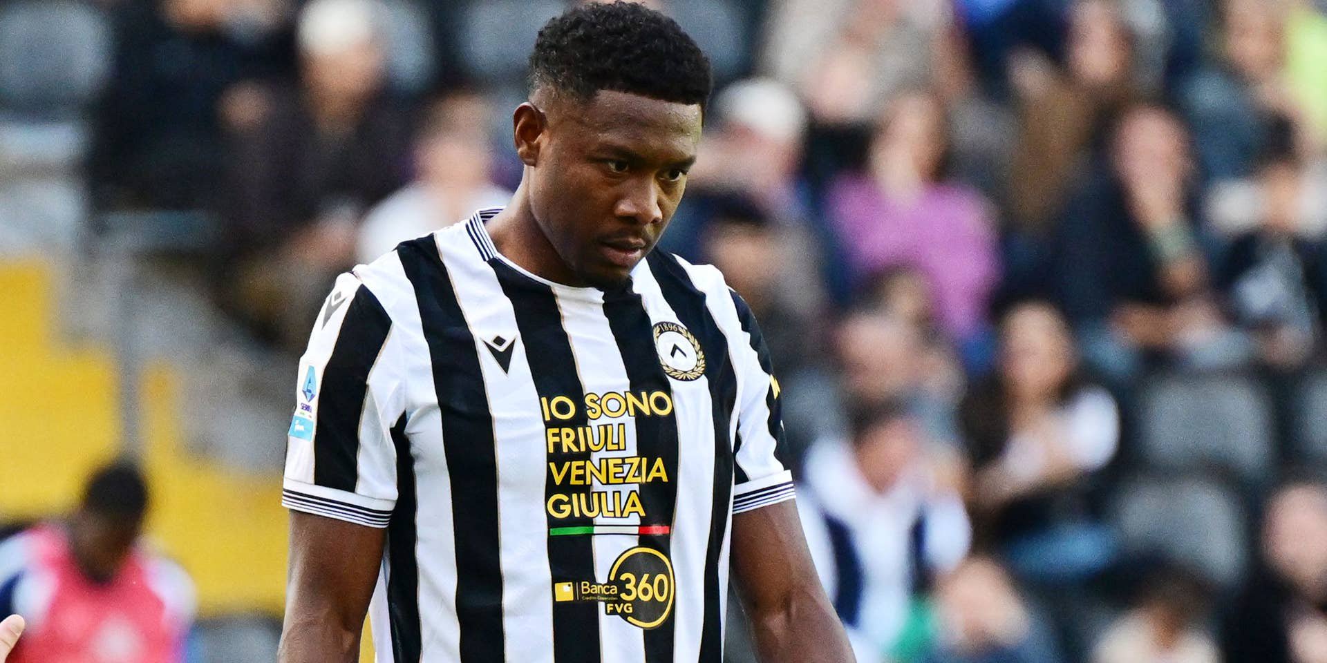 Ein Fußballspieler von Udinese Calcio steht nachdenklich auf dem Spielfeld.