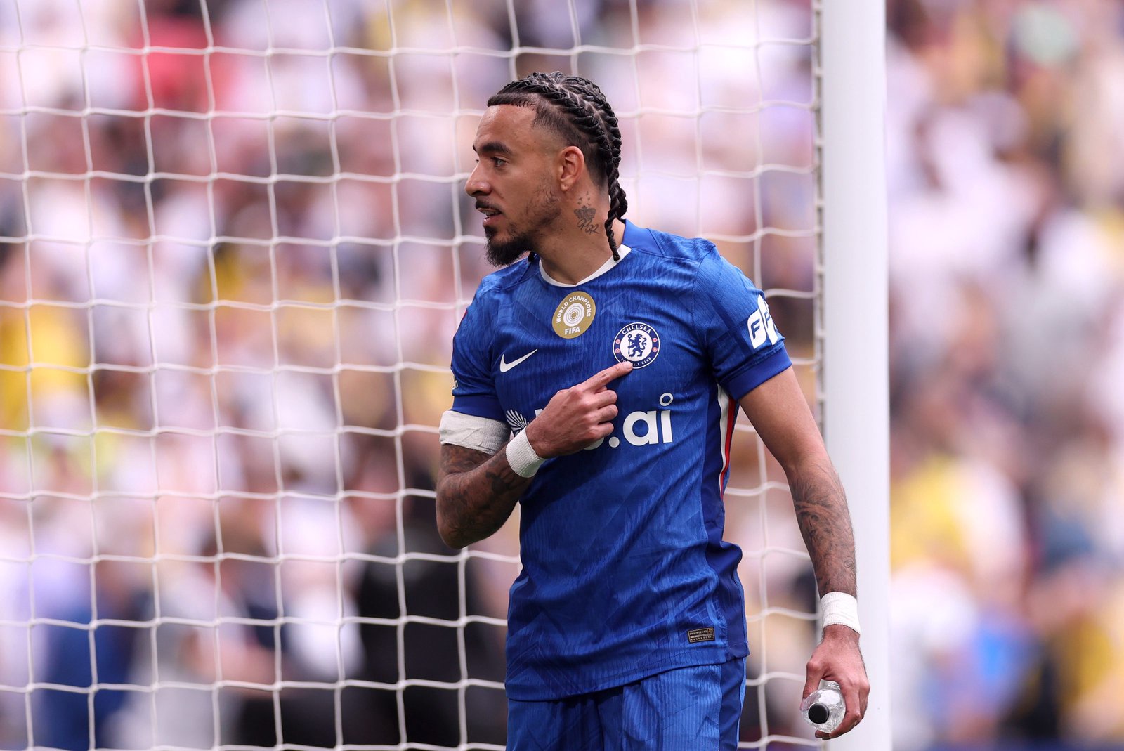 Malo Gusto touches the Chelsea badge.