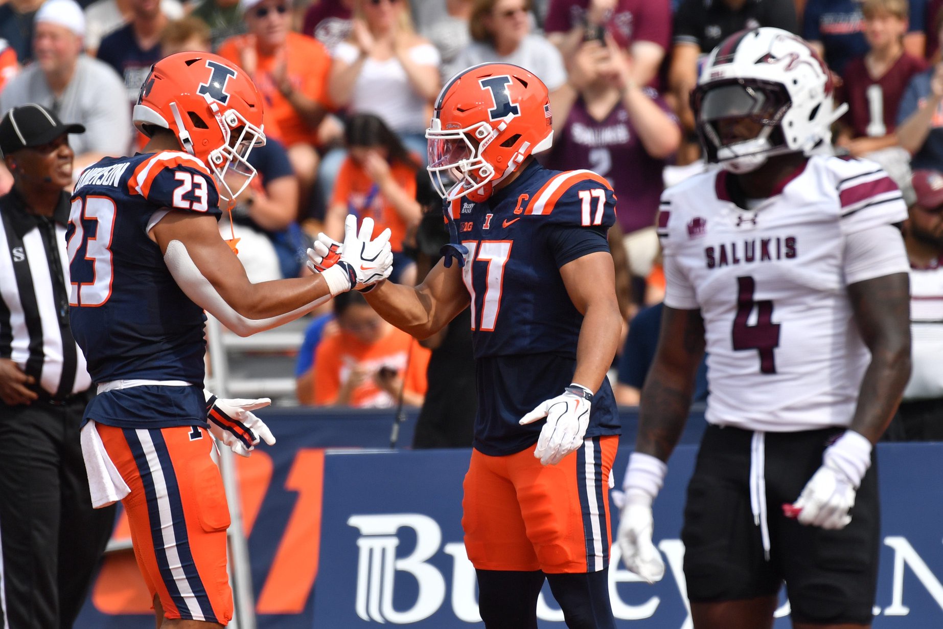 Illinois Fighting Illini running back Jordan Anderson (23) gives teammate and wide receiver Collin Dixon (17) a hand after Dixon scored a touchdown during the first half at Gies Memorial Stadium.