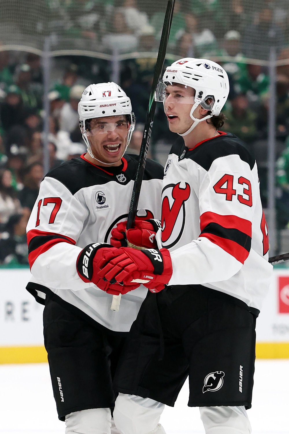 New Jersey Devils center Evan Rodrigues (17) celebrates with defenseman Luke Hughes (43) after a goal.