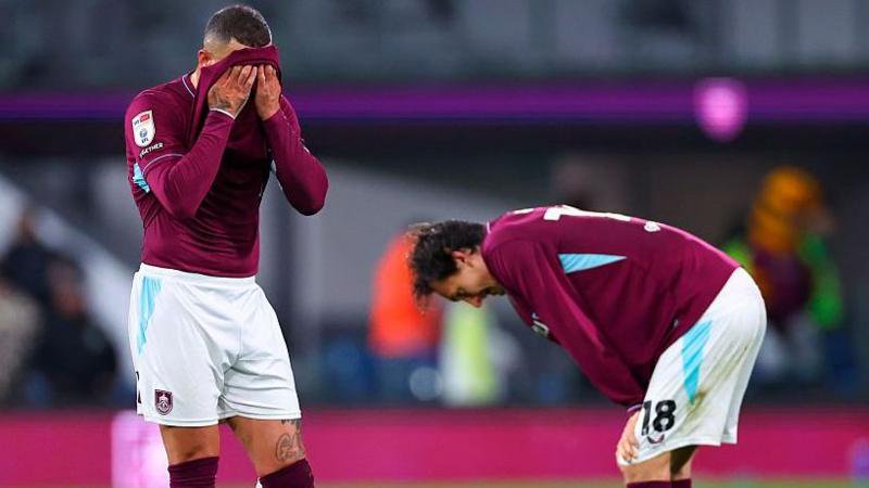 Burnley's Kyle Walker with a claret shirt over his face and Hjalmar Ekdal looking to the ground with his hands on his knees after defeat by Wolves