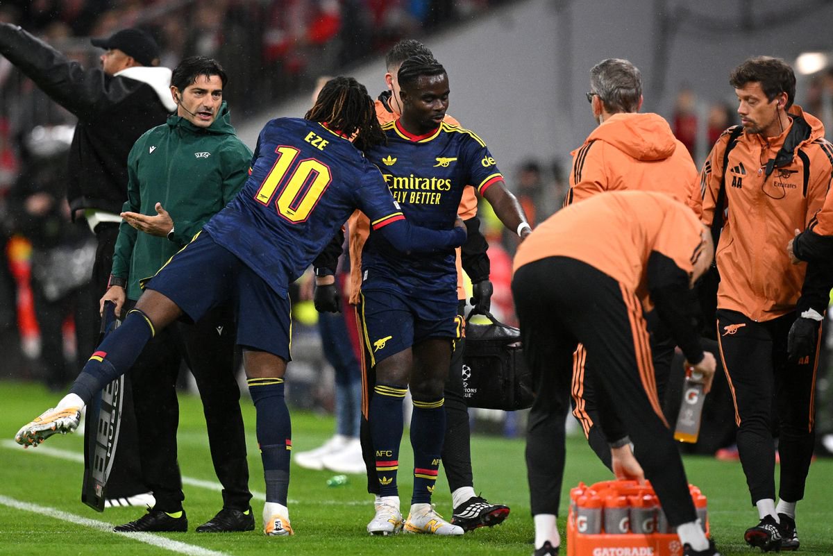Eberechi Eze interacts with teammate Bukayo Saka as he walks off the pitch due to an injury during the UEFA Champions League 2026/27 League Phase MD3 match between FC Bayern München and Arsenal FC. 