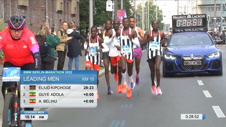 May be an image of 8 people and text that says 'MAURICE ጢ LACROIX 0:88:8日 THE 100% ELECTRIC. BRENAE KOPLI BMW BERLIN-MARATHON 2022 LEADING MEN KM 10 THE14 2 3 ELIUD KIPCHOGE GUYE ADOLA A. BELIHU 28:23 +0:00 +0:00 LEADING MEN 10.14 KM 0:28:52'
