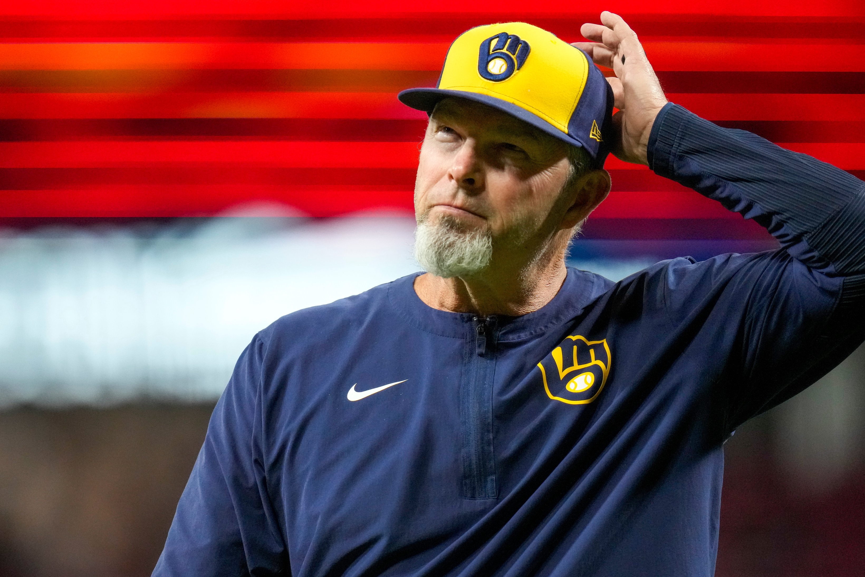 Milwaukee Brewers pitching coach Chris Hook (84) returns to the dugout after a mound visiting in the 10th inning of the MLB National League Central game between the Cincinnati Reds and the Milwaukee Brewers at Great American Ball Park in downtown Cincinnati on Monday, June 22, 2026. The Brewers won, 2-1, in 10 innings.