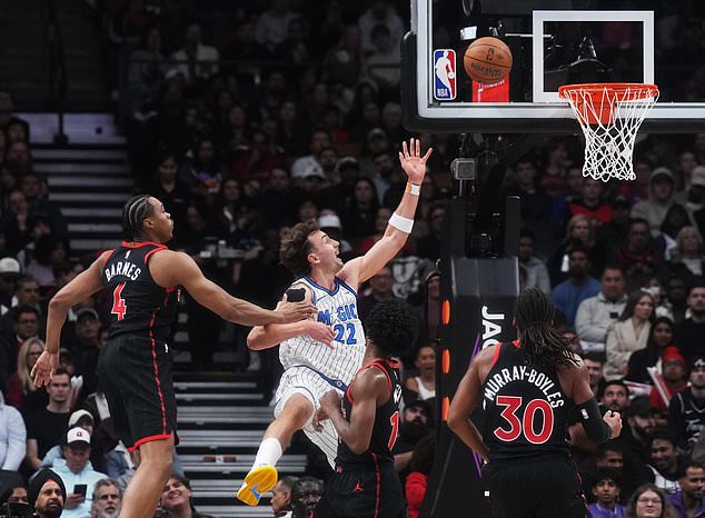 Orlando Magic's Franz Wagner (22) shoots past Toronto Raptors' Scottie Barnes (4) during the first half of an NBA Cup basketball game in Toronto, Friday, Oct. 30, 2026. (Nathan Denette/The Canadian Press via AP)