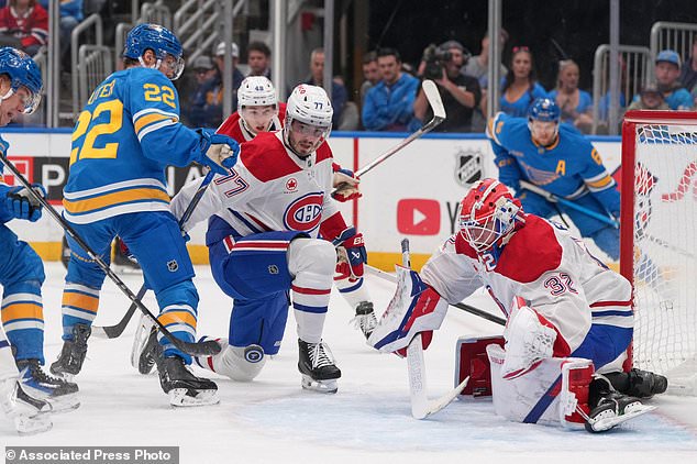 St. Louis Blues' Pius Suter (22) skates near a loose puck as Montreal Canadiens goaltender Jacob Fowler (32) and Kirby Dach (77) defend during the second period of an NHL hockey game Tuesday, Oct. 27, 2026, in St. Louis. (AP Photo/Jeff Roberson)
