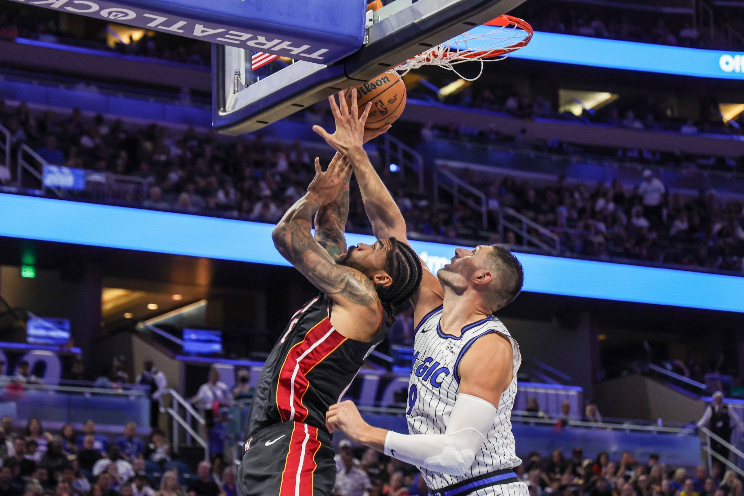 Oct 16, 2026; Orlando, Florida, USA;  Miami Heat center Nick Richards (8) is fouled by Orlando Magic center Nikola Vucevic (9) during the first quarter at Kia Center.  Mandatory Credit: Mike Watters-Imagn Images