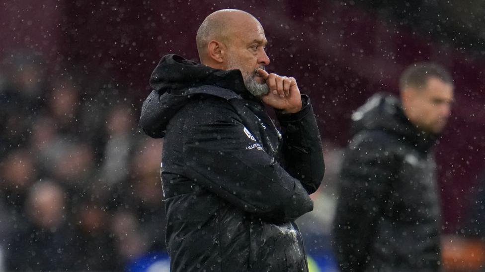 Nuno Espirito Santo stands with his hand on his mouth on the sideline at the London Stadium
