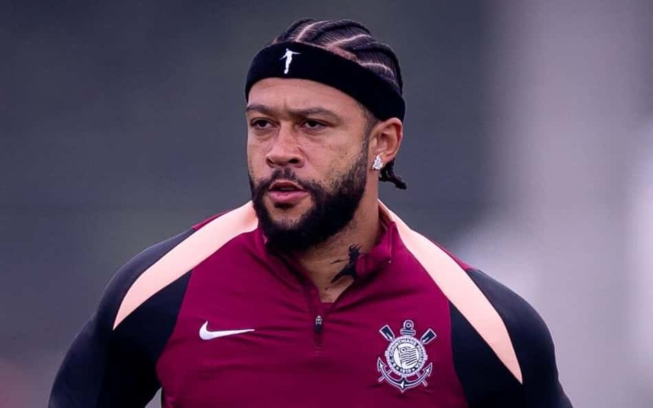 Memphis, atleta, com faixa preta, casaco vinho com detalhes rosa e emblema de time no peito, durante treino.