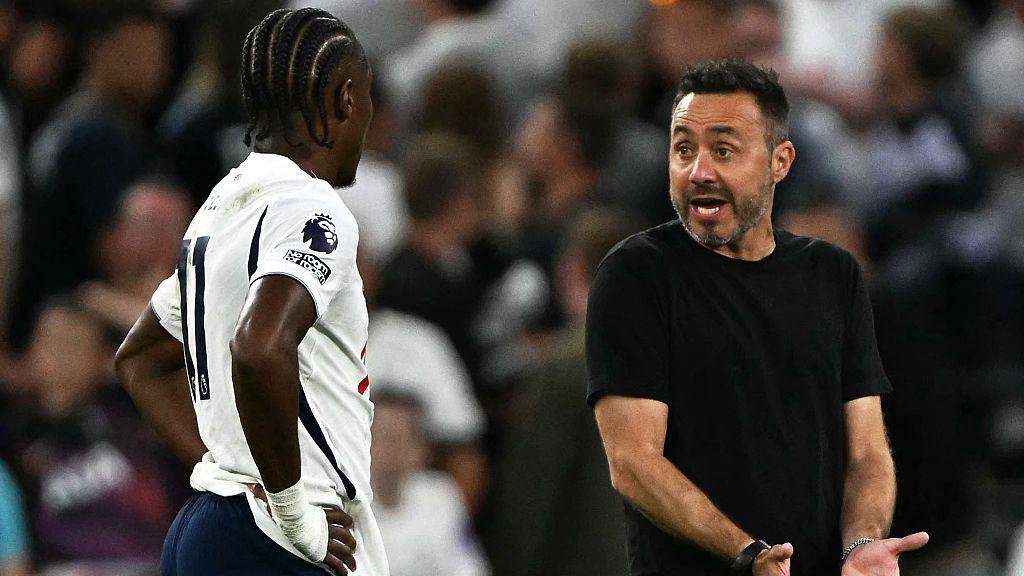 Tottenham midfielder Mathys Tel (L) listens to Italian head coach Roberto de Zerbi (R)