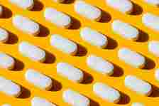 a photo of a vitamin capsule photographed on a yellow background