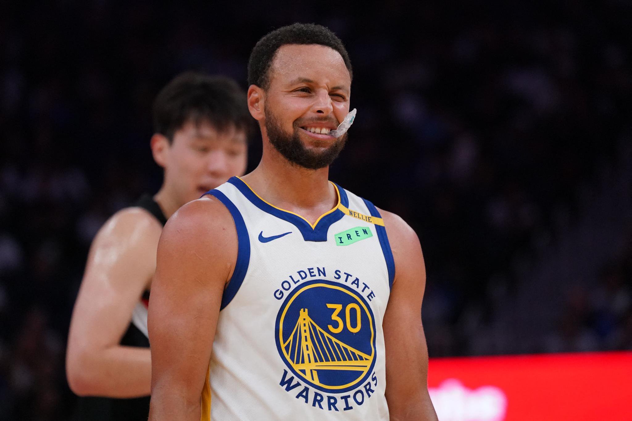 Golden State Warriors guard Stephen Curry reacts with a mouthpiece hanging from his mouth during a game against the Portland Trailblazers.