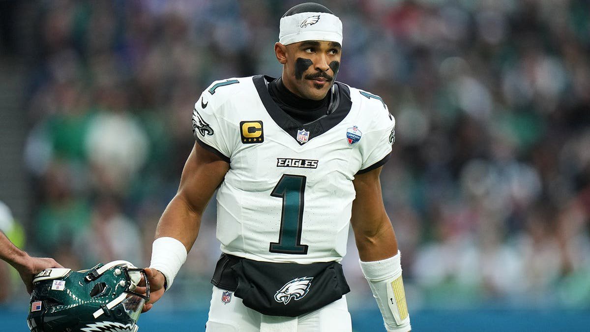 Jalen Hurts stands on the field during an NFL game in London.