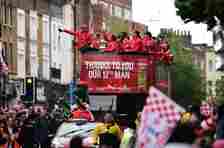 Arsenal players stand with the trophy as they wave to fans from the top deck of an open-topped bus during the Arsenal victory parade in London on May 31, 2015, following their win in the English FA Cup final football match on May 30, 2014 against Aston Villa. Arsene Wenger's side made history at Wembley with a 4-0 rout of Aston Villa that underlined their renaissance in the second half of the campaign and served as a warning to English champions Chelsea. AFP PHOTO / LEON NEAL (Photo credit should read LEON NEAL/AFP via Getty Images)