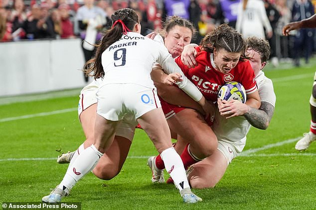 Canada's DaLeaka Menin, second from right, is tackled by England's Hannah Botterman, right, during the first half of a women's rugby match in Toronto, Friday, Oct. 16, 2026. (Arlyn McAdorey/The Canadian Press via AP)