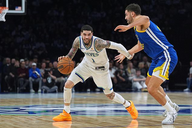 Minnesota Timberwolves guard LaMelo Ball, left, works toward the basket as Golden State Warriors forward Georges Niang, right, defends during the first half of an NBA basketball game, Wednesday, Oct. 28, 2026, in Minneapolis. (AP Photo/Abbie Parr)