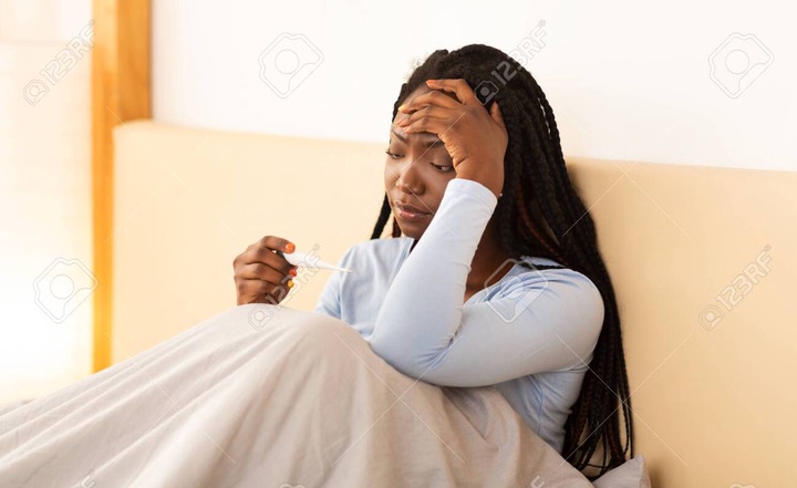 Fever And Headache. Sick African American Lady Holding Thermometer Touching  Head Sitting In Bed At Home. Stock Photo, Picture And Royalty Free Image.  Image 137331155.