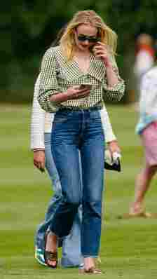 Sophie Turner wears a Peter Pan collar shirt with jeans and sandals at a polo match