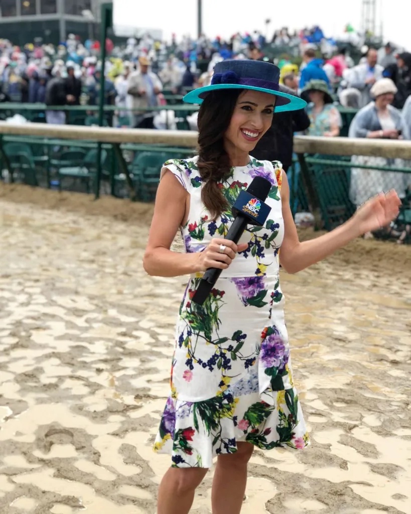 NBC Sports reporter Britney Eurton at the Preakness Stakes, holding a microphone on a muddy racetrack.