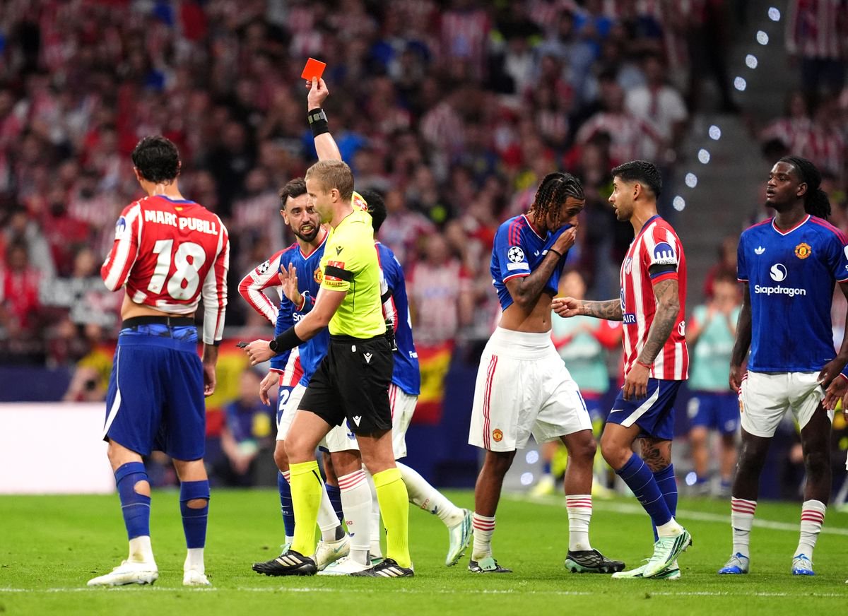Referee Glenn Nyberg shows a red card to Manchester United defender Leny Yoro.