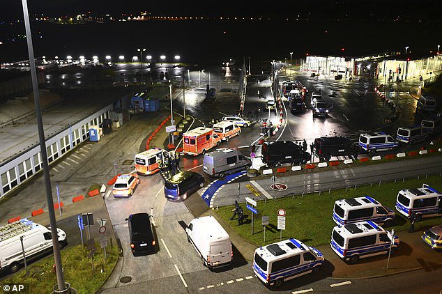 Police vehicles and ambulances arrive at the scene of a security breach at the Hamburg Airport last night