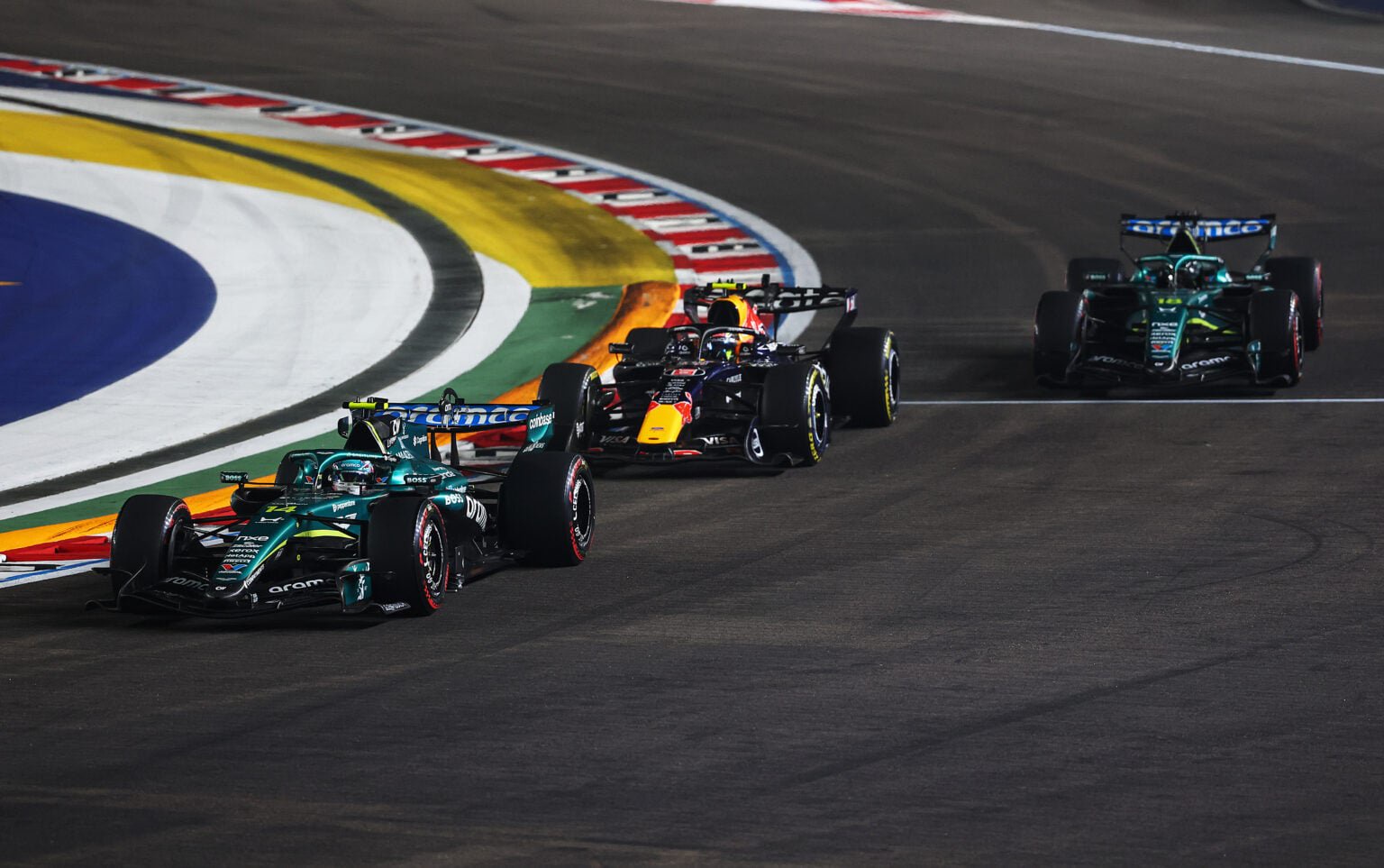 Red Bull's Isack Hadjar on track with Aston Martin's Fernando Alonso and Lance Stroll during the 2026 F1 Singapore Grand Prix