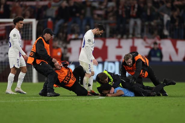 MUNICH, GERMANY - MARCH 08: Warren Zaire-Emery and Lionel Messi of PSG look on as a pitch invader that attempted to make contact with the PSG number 30 is dealt with by stewards following the final whistle of the UEFA Champions League round of 16 leg two match between FC Bayern MÃ¼nchen and Paris Saint-Germain at Allianz Arena on March 08, 2023 in Munich, Germany.
