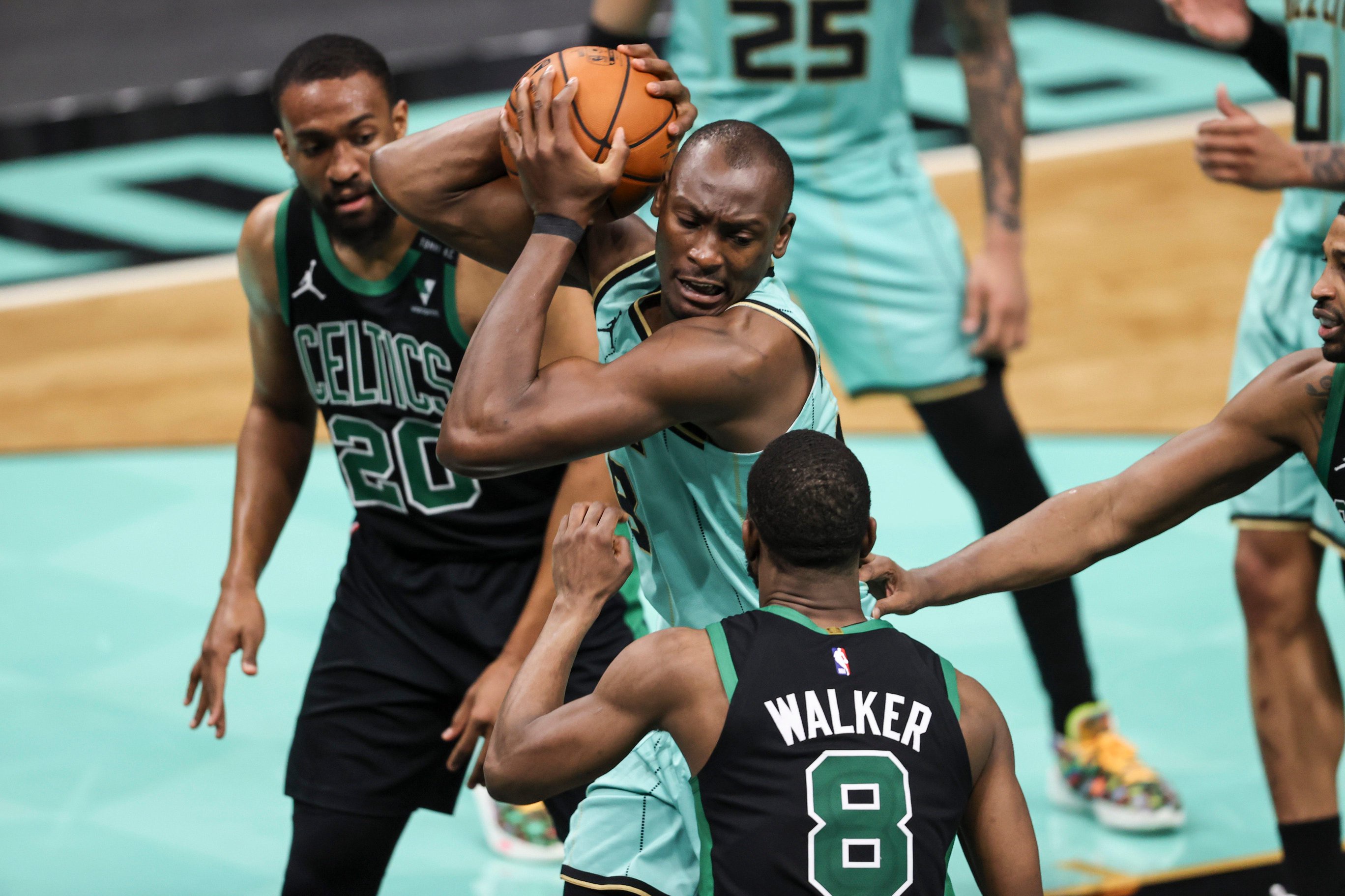 Apr 25, 2021; Charlotte, North Carolina, USA; Charlotte Hornets center Bismack Biyombo (8) pulls down a rebound against Boston Celtics forward Jabari Parker (20) and guard Kemba Walker (8) in the second half at Spectrum Center. The Charlotte Hornets won 125-104. Mandatory Credit: Nell Redmond-USA TODAY Sports