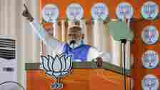 Modi raises a hand while speaking at an election campaign rally, in New Delhi, India,