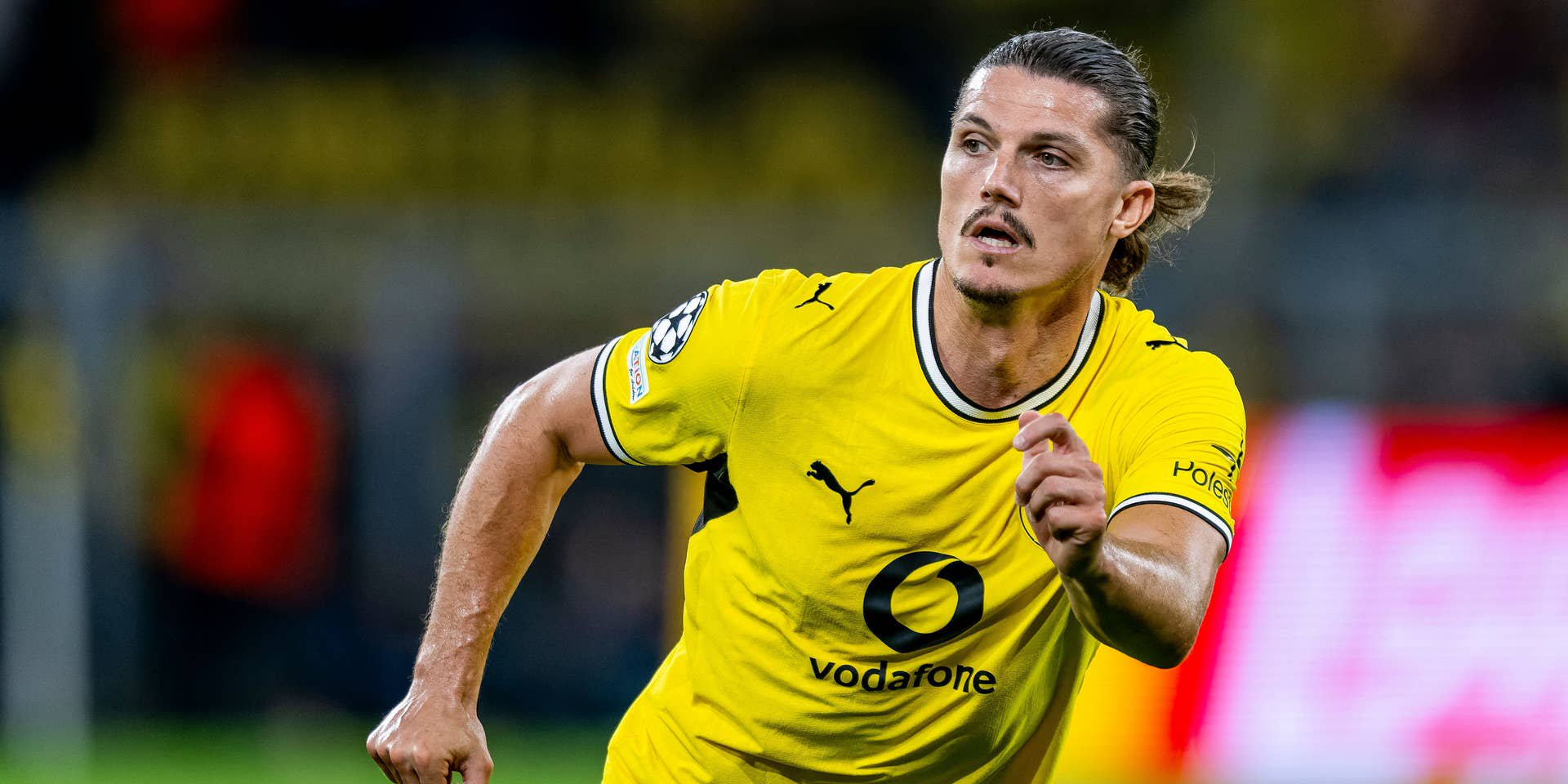 Ein Fußballspieler von Borussia Dortmund läuft im gelben Trikot über das Spielfeld.