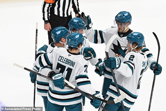 San Jose Sharks defenseman Dmitry Orlov, center left, is congratulated by teammates after scoringh a goal during the first period of an NHL hockey game against the Detroit Red Wings, Saturday, Oct. 17, 2026, in Detroit. (AP Photo/Jose Juarez)
