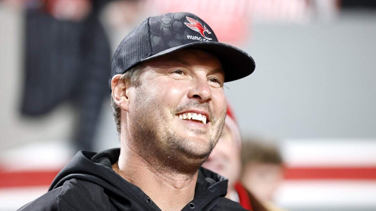 Former N.C. State quarterback Philip Rivers smiles as he stands on the sidelines before the Wolfpack’s game against UNC at Carter-Finley Stadium in Raleigh, N.C., on Nov. 29, 2025.