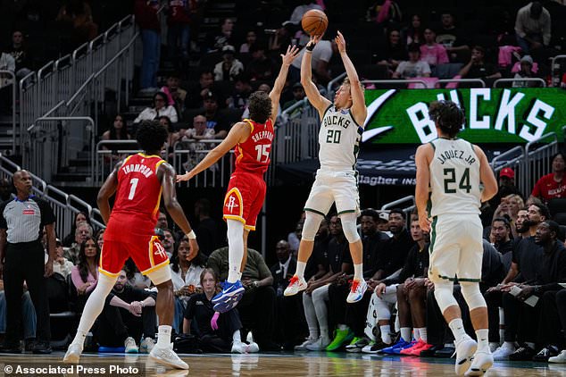 Milwaukee Bucks guard AJ Green (20) scores a three-point basket against Houston Rockets guard Reed Sheppard (15) during the first half of an NBA basketball game Wednesday, Oct. 28, 2026, in Milwaukee. (AP Photo/Kayla Wolf)