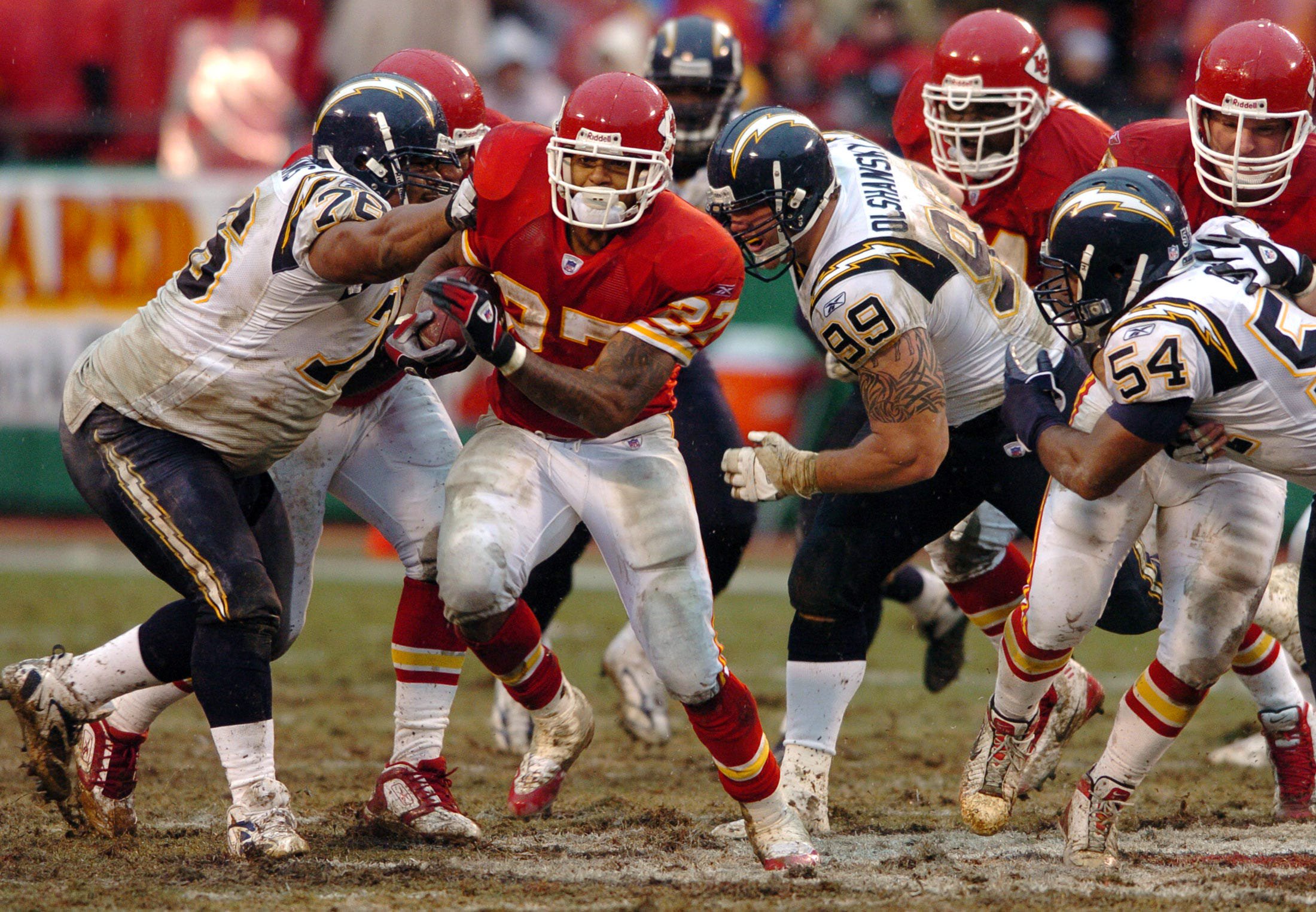 Kansas City Chiefs running back Larry Johnson (C) evades a trio of San Diego Chargers defenders to make a first half gain during their NFL game in Kansas City, Missouri December 24, 2005. REUTERS/Dave Kaup