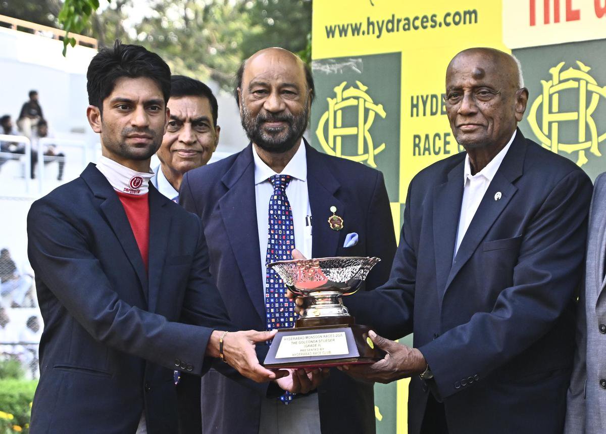 A sombre looking Trevor receiving the winner’s trophy from HRC chairman R. Surender Reddy.