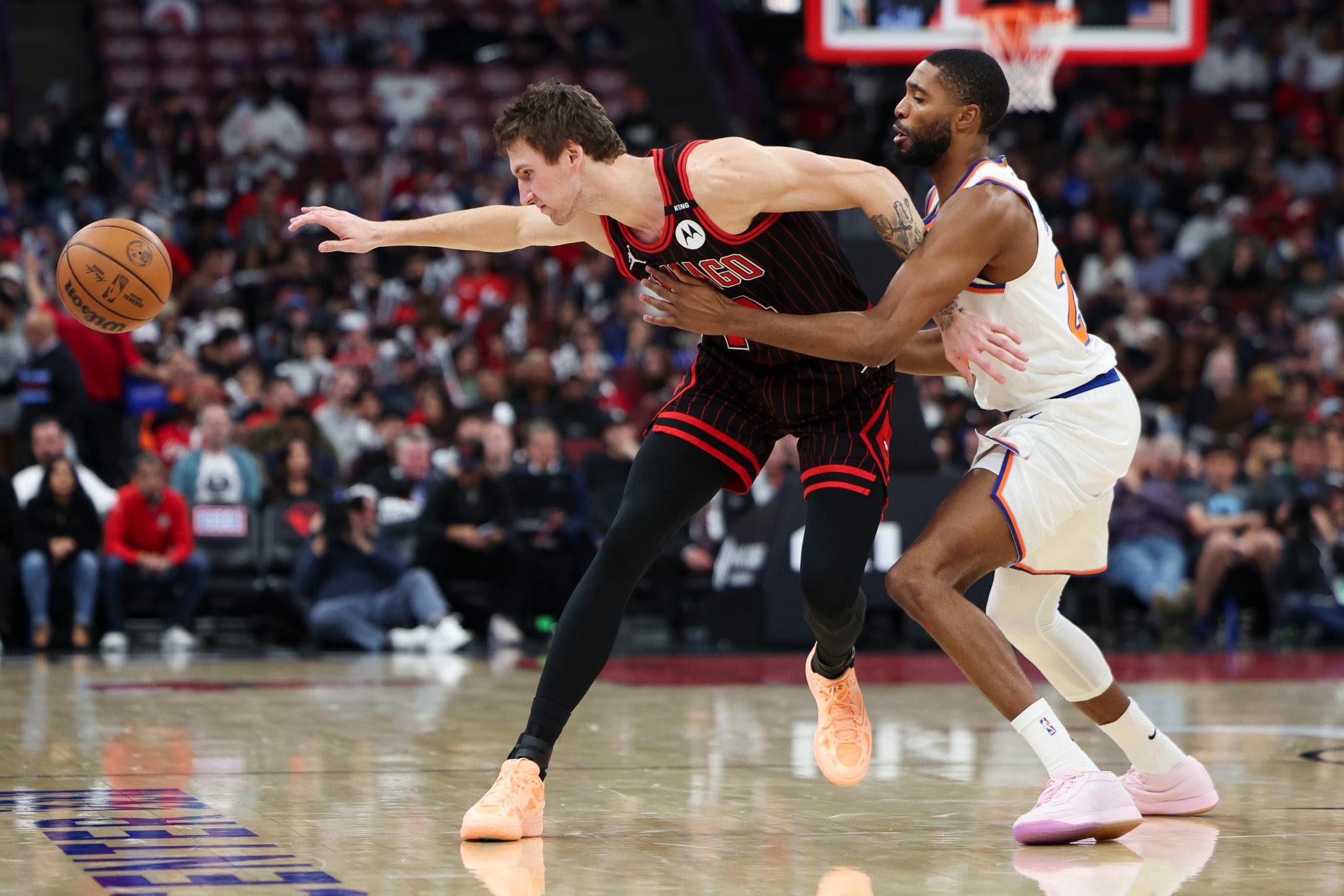 New York Knicks and Chicago Bulls players battle for the loose basketball.