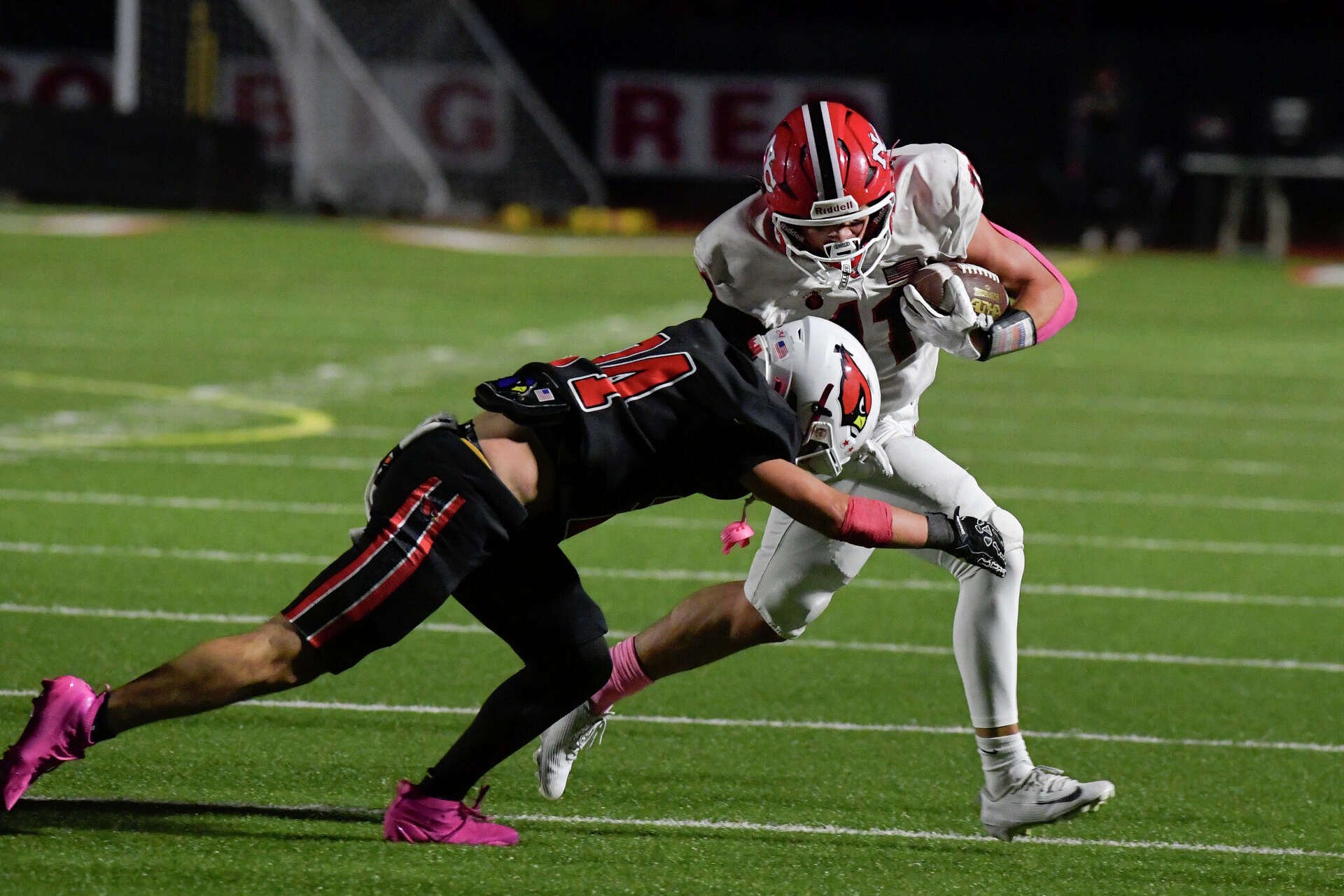 New Canaan’s Dallas George (11) gets taken down by Greenwich’s Colin Suvansri (24) in the CIAC football game between the state's top two ranked teams, No. 1 New Canaan and No. 2 Greenwich high schools. Friday, October 23, 2026, Greenwich High School, Greenwich, Conn.