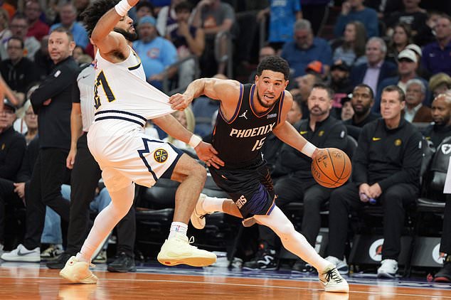 Phoenix Suns guard Devin Booker (15) drives around Denver Nuggets guard Jamal Murray, left, during the first half of an NBA Cup basketball game, Friday, Oct 30, 2026, in Phoenix. (AP Photo/Rick Scuteri)