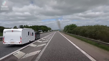 As they approach the route via a slip road, a caravan overtakes on the outside