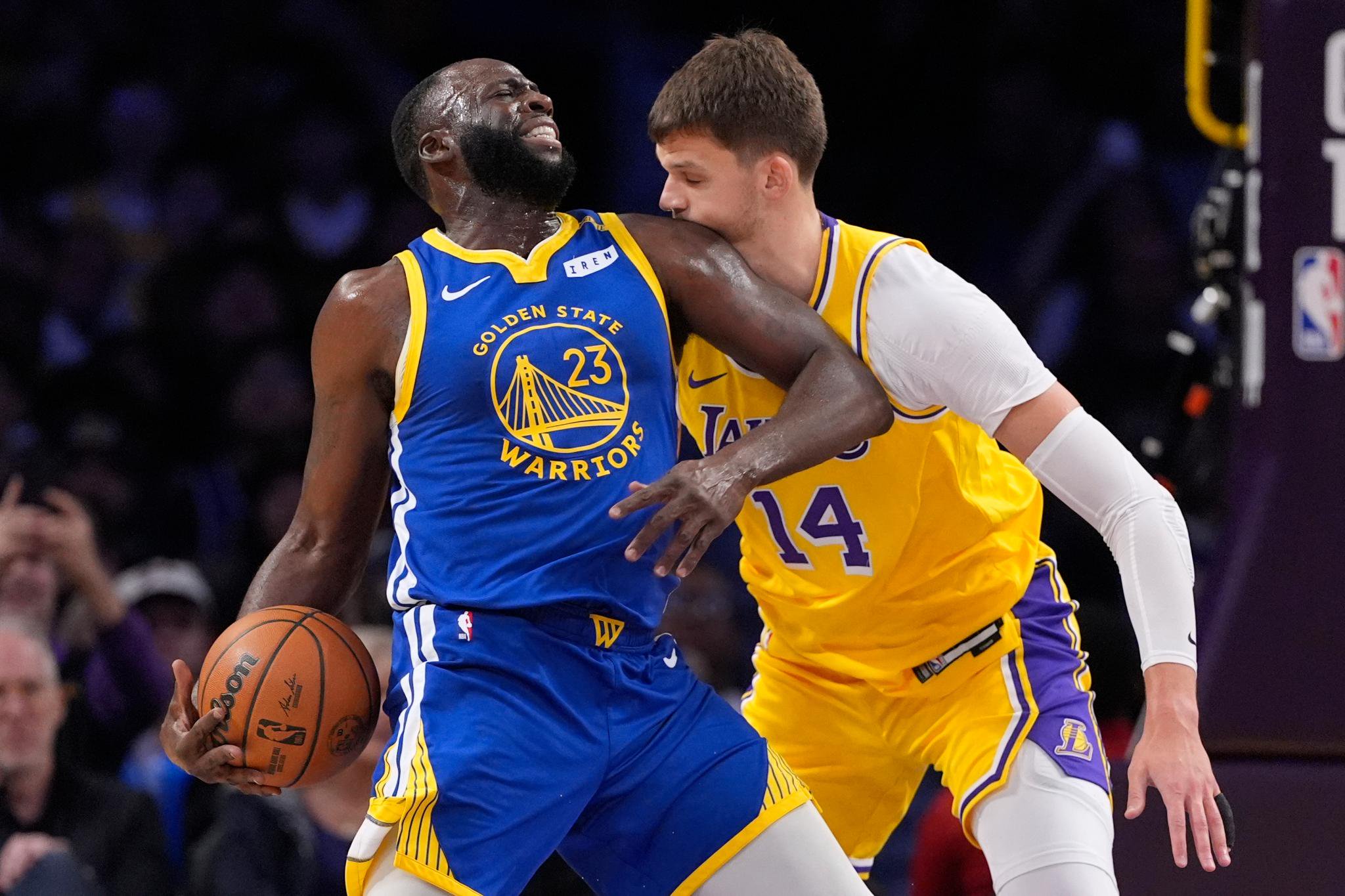 Los Angeles Lakers center Walker Kessler, right, is hit in the face by Golden State Warriors forward/center Draymond Green