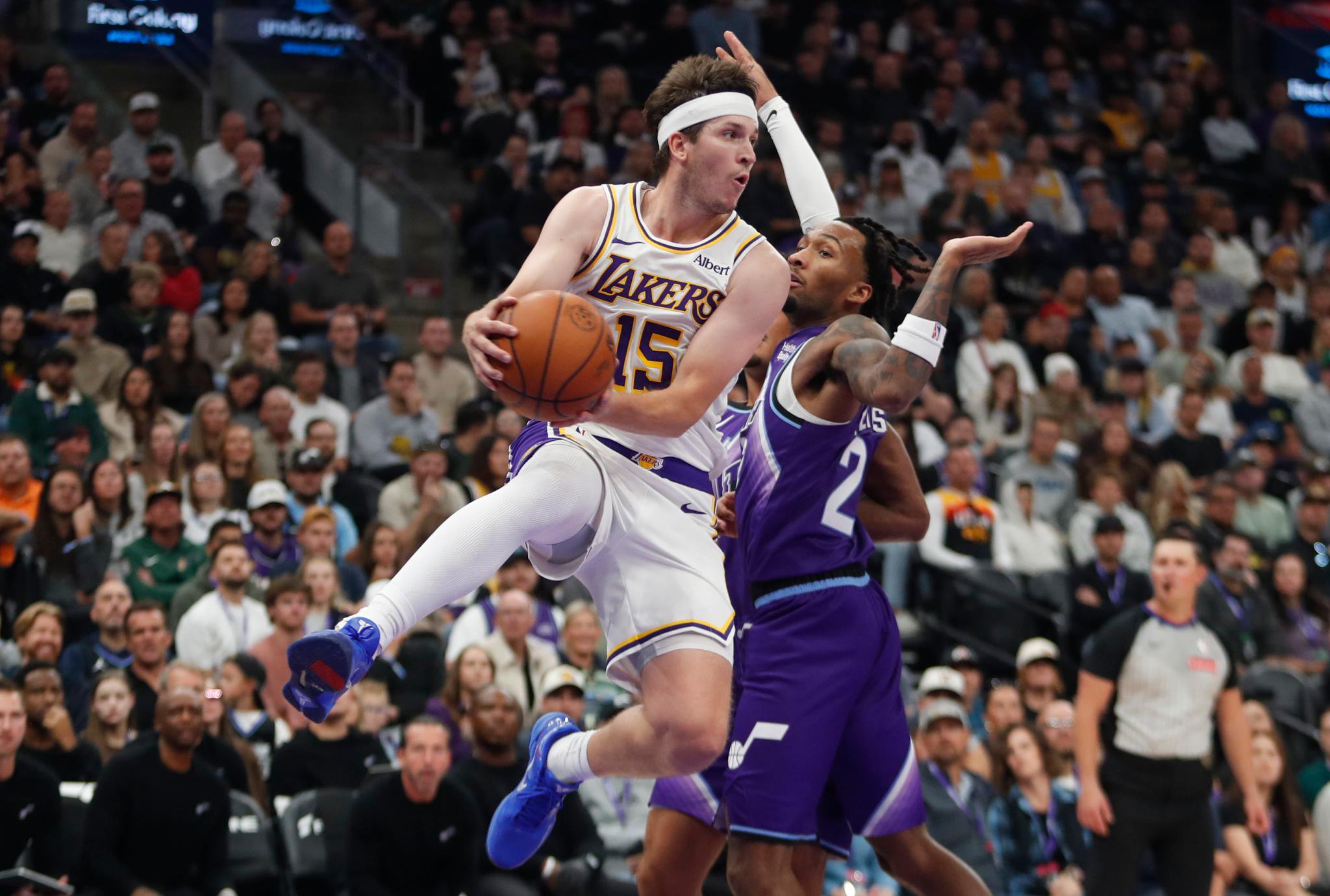 Austin Reaves of the Los Angeles Lakers drives to the basket against Darryn Peterson of the Utah Jazz.