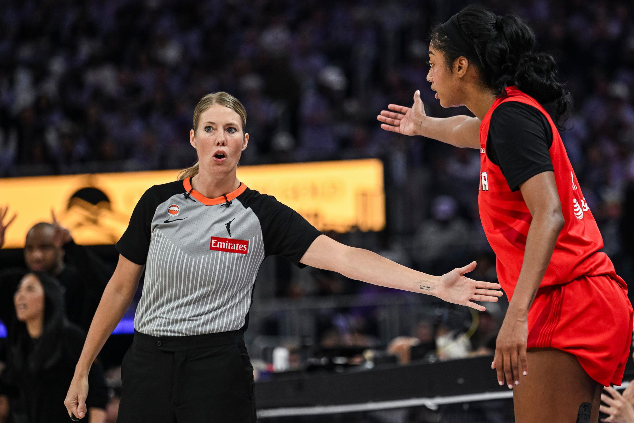 Referee Angelica Suffren talks with Angel Reese during a game.