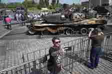 Pictured: A man takes a selfie in front of a US-made M1 Abrams tank, hit and captured by Russian troops during the fighting in Ukraine as they visit an exhibition of Western military equipment seized from Ukrainian forces, in Moscow, May 31