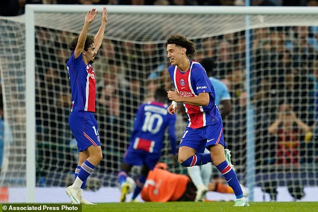 PSG's Maghnes Akliouche, center, celebrates after scoring his side's fourth goal during the Champions League opening phase soccer match between Manchester City and Paris Saint-Germain in Manchester, England, Wednesday, Oct. 14, 2026. (AP Photo/Dave Thompson)