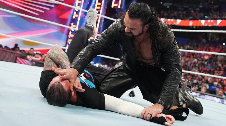 Drew McIntyre pinning CM Punk down after attacking him during a "RAW" match.
