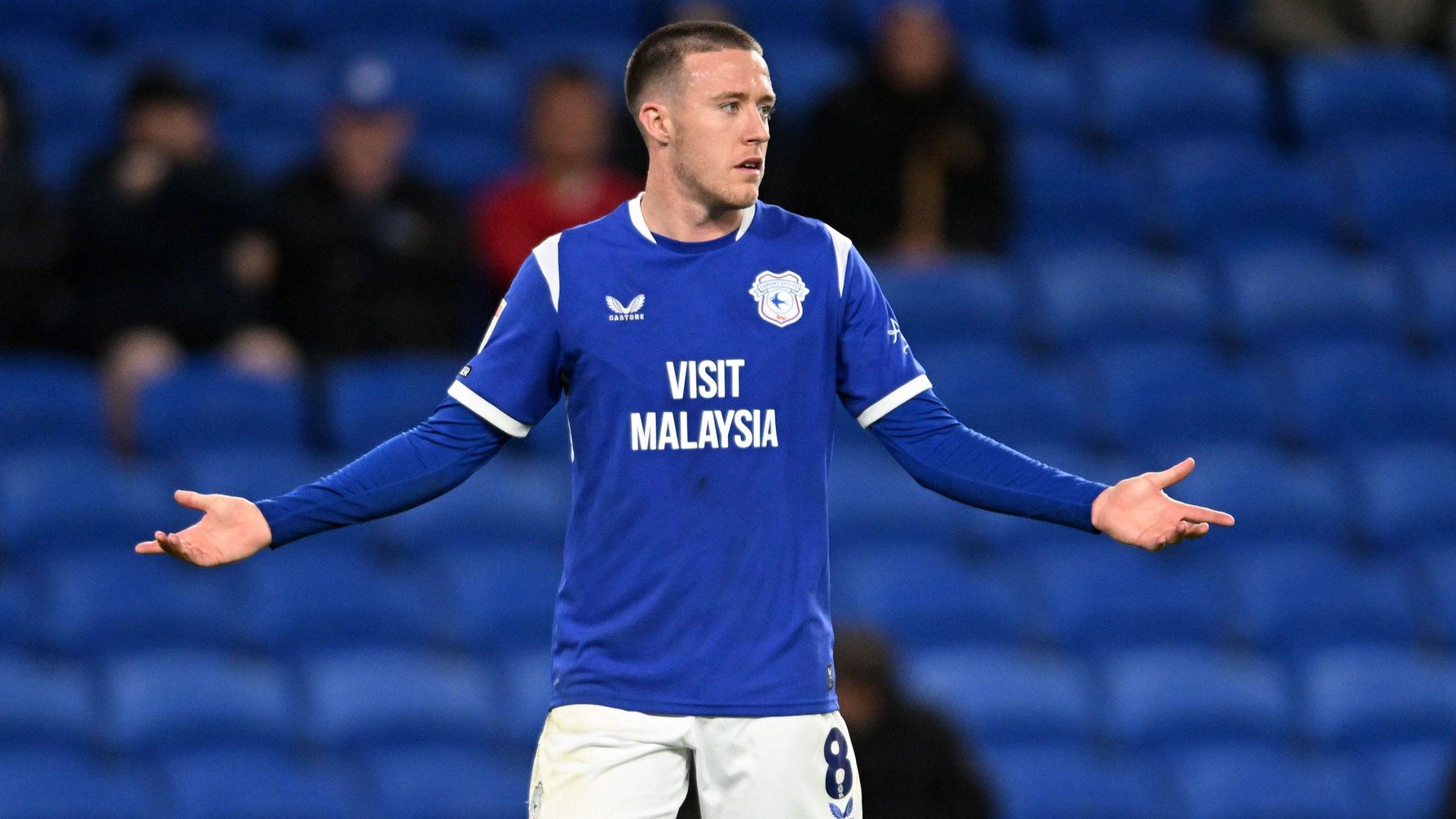 Jack Moylan in a blue Cardiff City shirt with his arms outstretched