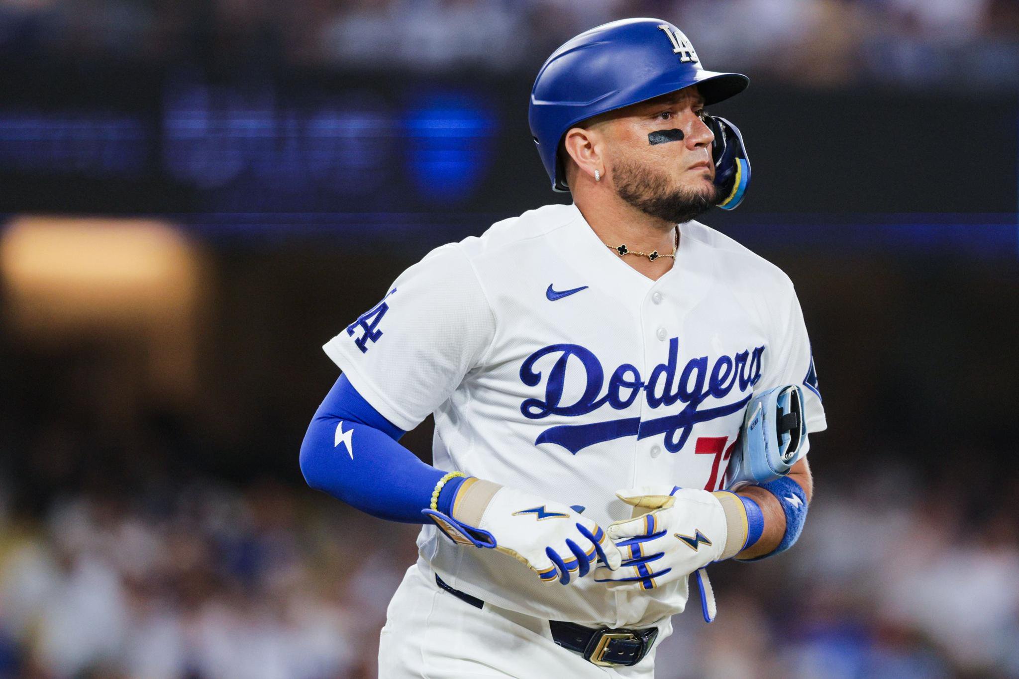 Dodgers second baseman Miguel Rojas looking forward as he runs to first base.