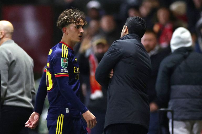Mikel Arteta, Manager of Arsenal, talks to Max Dowman of Arsenal as he walks off the pitch after being sent off during the Carabao Cup Fourth Round match at Fleetwood Town