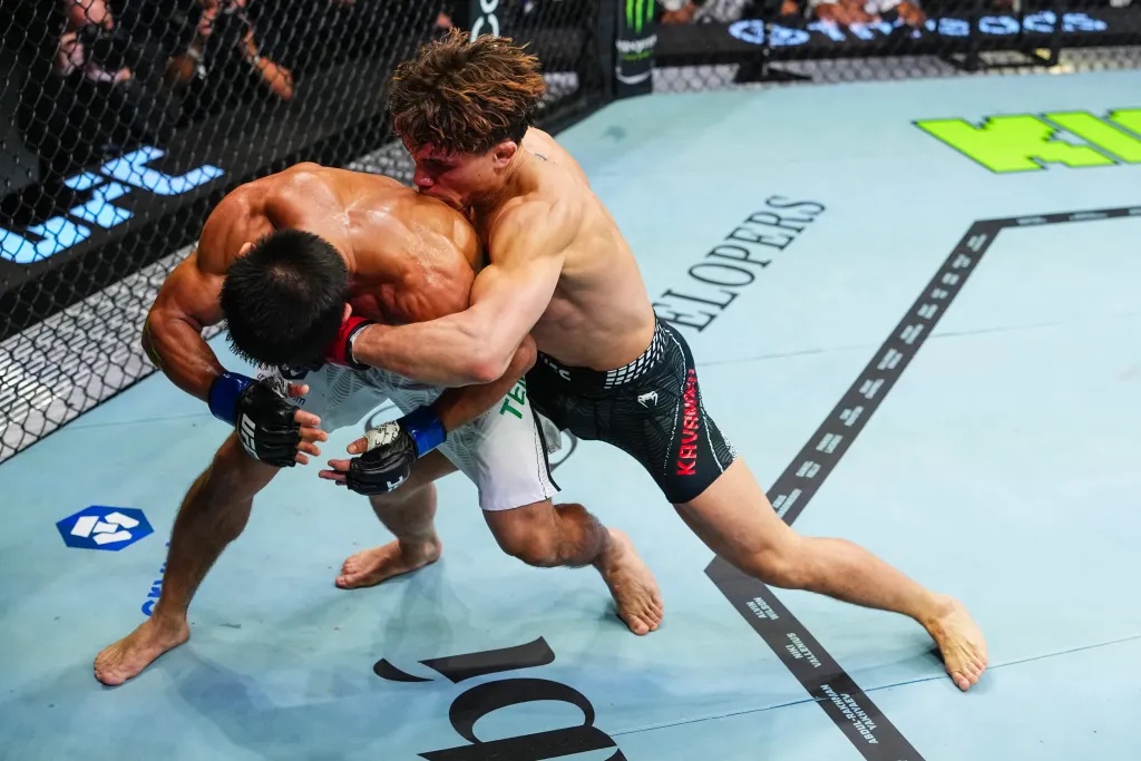 Lone’er Kavanagh grapples with Ramazan Temirov during a flyweight UFC fight inside the octagon.
